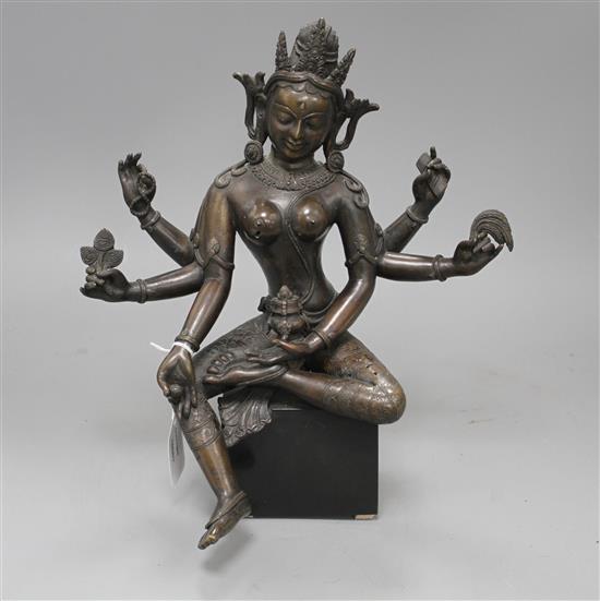 A Sino-Tibetan bronze figure of a seated female deity, on associated marble plinth, height 35cm